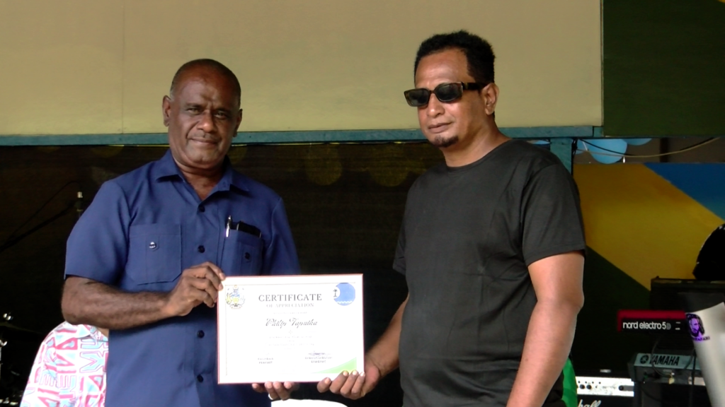 PM Manele presenting certificate to logo winner, Mr. Philip Tapuika